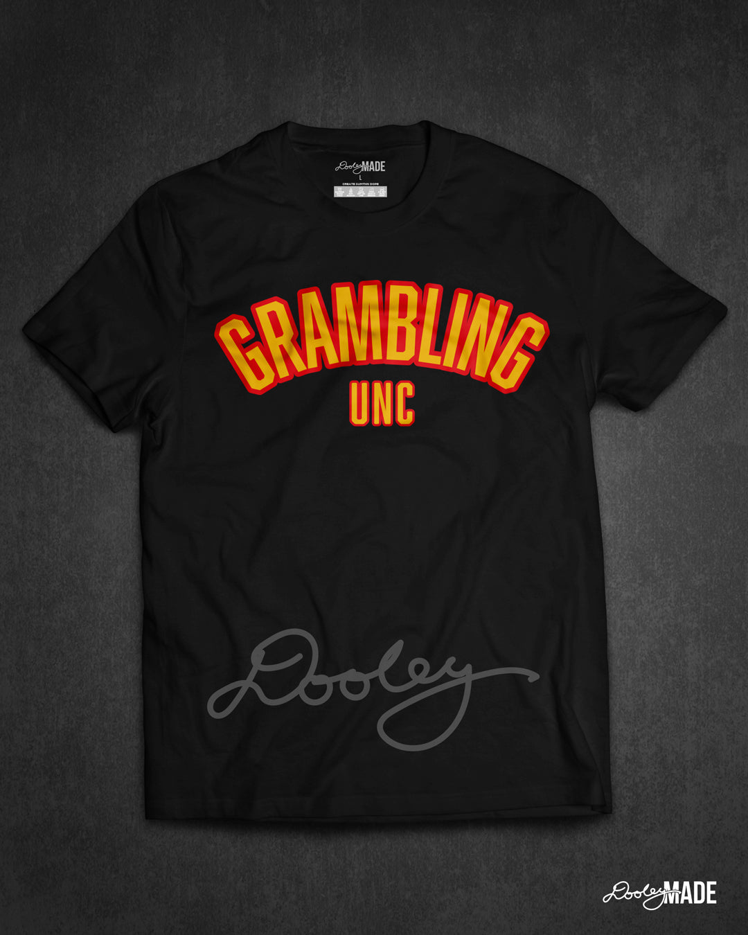 A black "Grambling Unc" shirt with arched wording in gold and black.