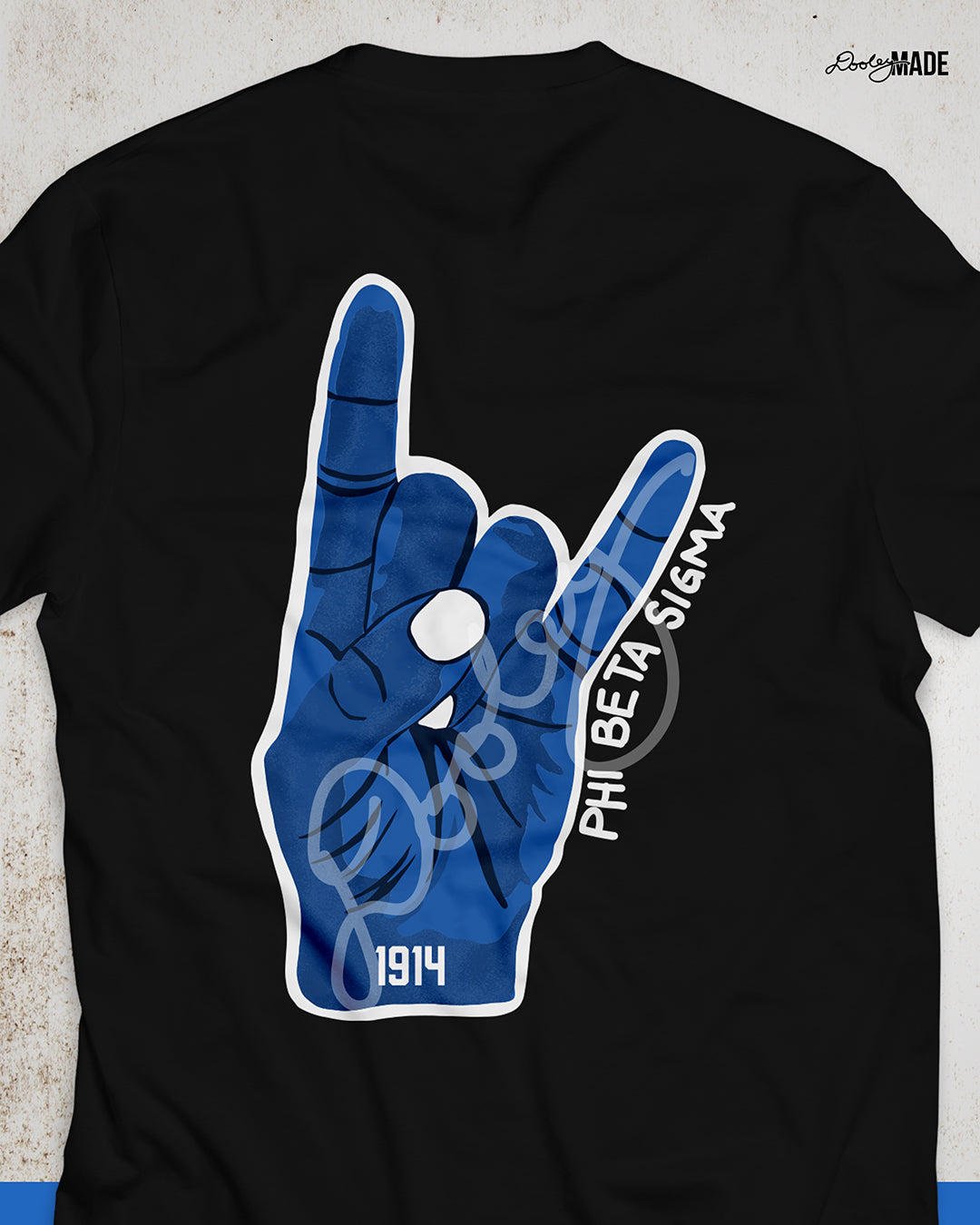 An image of the back of a black Phi Beta Sigma Fraternity, Inc. Shirt featuring a large Sigma Hand Sign. 1914 is written on the wrist in bold black font and "Phi Beta Sigma" is written in along the side in a handwritten font.