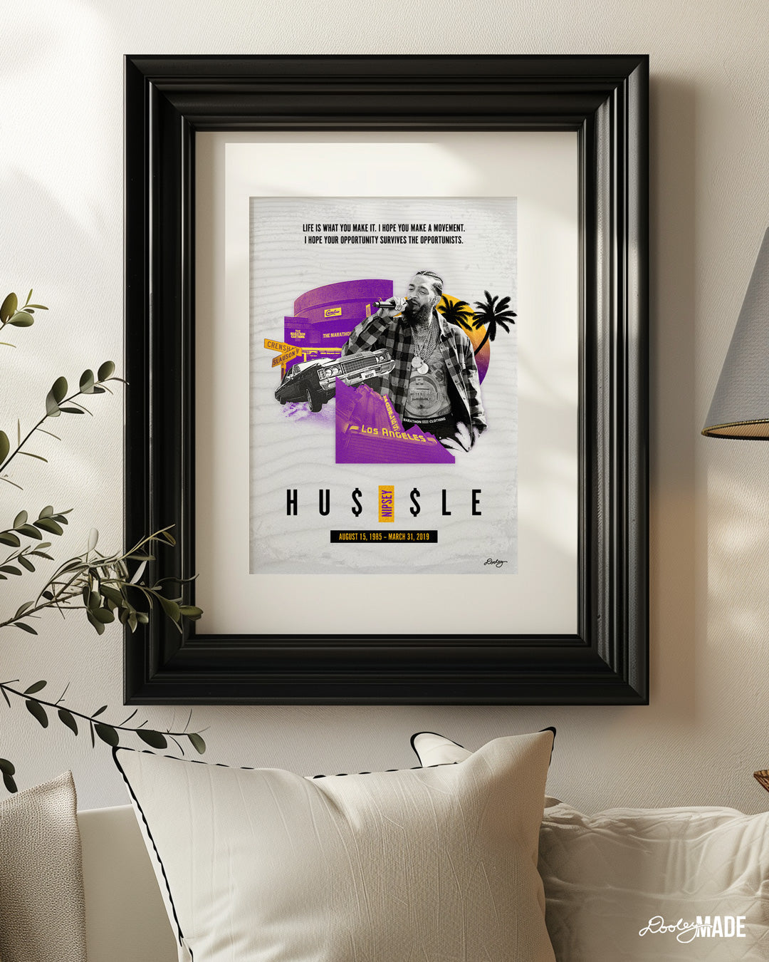 Framed Nipsey Hussle printed artwork titled "Sunsets on Slauson" in a bright, warm living room featuring Los Angeles purple and gold, The Marathon store on Slauson, a Chevy with "Nipsey" plates, The Los Angeles Theatre, a sunset, and palm trees. Add a touch of LA to your space with this dope Nipsey Hussle print!