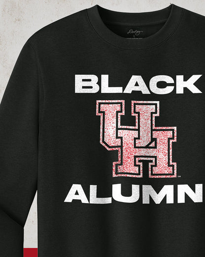 Image of a black "Black UH Alumni Crewneck Sweatshirt" with bold, white text reading "BLACK ALUMNI" surrounding a speckled red "UH" logo in the center. The design highlights pride and unity for Black Alumni of the University of Houston, presented on a modern and stylish garment perfect for showing school spirit.